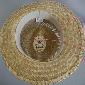 Peut inclure: Un chapeau de paille avec un motif tiss&eacute; brun. L'int&eacute;rieur du chapeau a une bande de tissu blanc avec une doublure en maille et une &eacute;tiquette qui indique "Original Panama Jack".