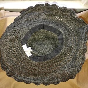 May include: A black crochet sun hat with a scalloped edge. The hat is made of a fine, open weave material.