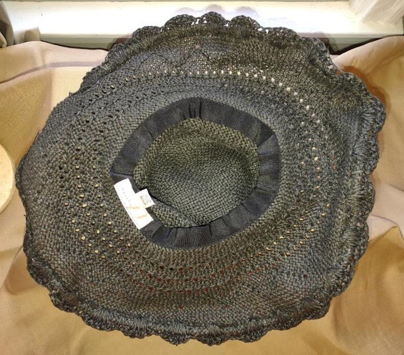 May include: A black crochet sun hat with a scalloped edge. The hat is made of a fine, open weave material.