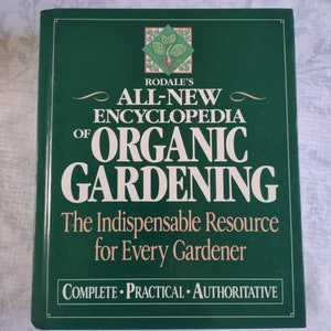 May include: A green book titled "Rodale's All-New Encyclopedia of Organic Gardening" with the subtitle "The Indispensable Resource for Every Gardener" and the words "Complete Practical Authoritative" at the bottom.