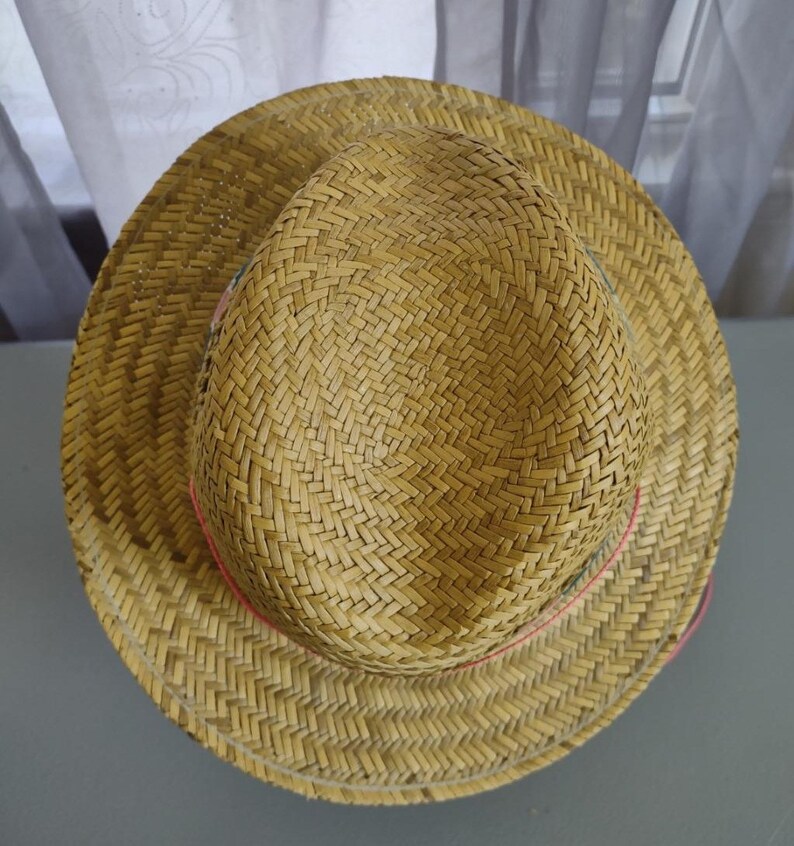 Peut inclure: Un chapeau de paille avec une texture tiss&eacute;e et un ruban rose autour du bord.