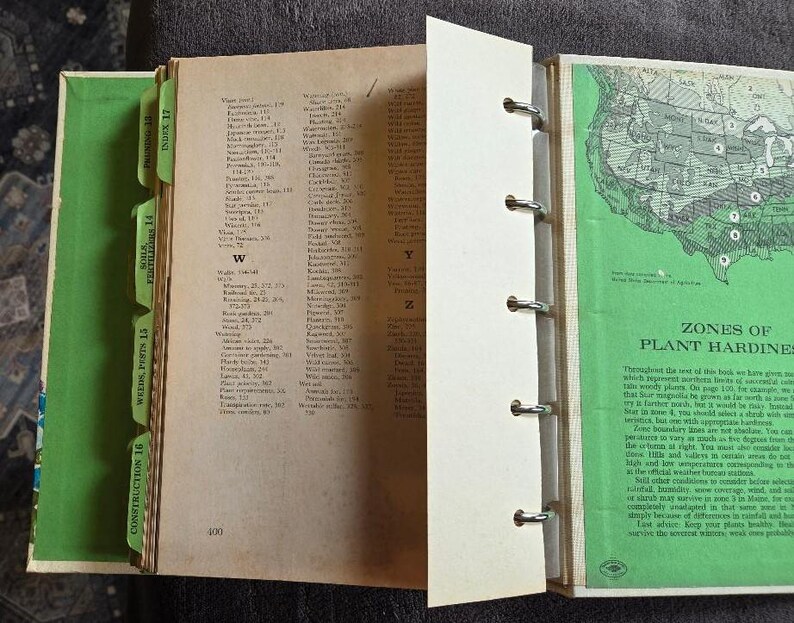 May include: An open vintage book with a green cover and tabs. The pages are filled with text and a map of the United States. The book is bound with metal rings. The tabs read: Construction 16, Weeds, Pests 15, Soils, Fertilizers 14, and Index 17.