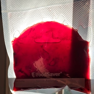 May include: A red liquid is inside a clear plastic bag with the FoodSaver logo and the words "Contents/Contenu/Contenido".