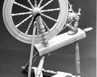 May include: A wooden spinning wheel with a large wheel and a smaller wheel with a spindle. The spinning wheel is on a wooden stand with three legs.