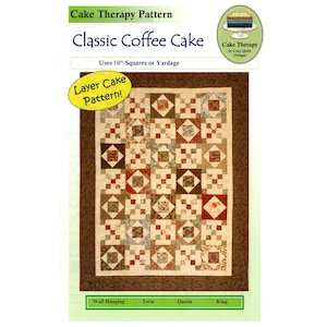May include: A quilt pattern titled "Classic Coffee Cake" by Cake Therapy. The quilt design features a patchwork of squares in shades of brown, beige, and red. The pattern uses 10-inch squares or yardage and is suitable for wall hanging, twin, queen, and king sizes.