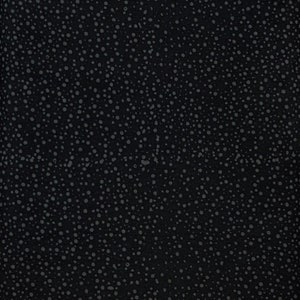 May include: A close-up view of a black fabric with a pattern of small, evenly spaced gray dots. The dots vary slightly in size and are scattered across the surface, creating a textured appearance. The dark background enhances the visibility of the dots.