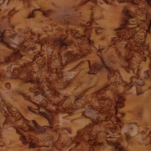 May include: Abstract textile pattern in shades of brown and tan. The design features a mottled appearance with areas of lighter and darker tones, creating a textured, organic look. The fabric appears to have a batik or tie-dye effect.