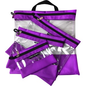 May include: A set of purple and clear zippered pouches and a tote bag. The pouches have black zippers and silver zipper pulls. The tote bag has a black handle. The clear sections of the pouches allow visibility of the contents. The text "Clearly Organized" is printed on the pouches.