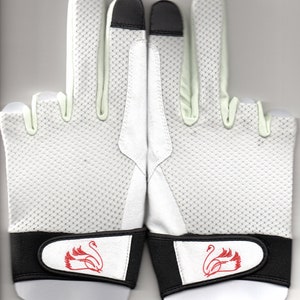 May include: Pair of white golf gloves with black accents. The gloves feature a breathable mesh design, black fingertips, and a red swan logo on the wrist strap. The gloves are designed for comfort and grip during play.