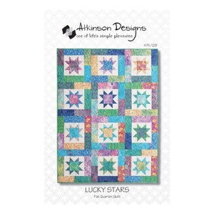 May include: A colorful quilt pattern featuring a repeating star design. The quilt has a patchwork design with squares of various colors, including blue, green, pink, and yellow. The text "LUCKY STARS" and "Fat Quarter Quilt" are visible.