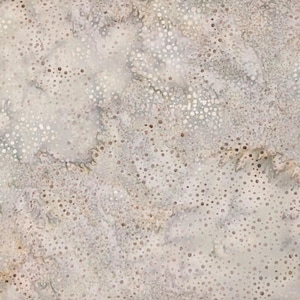 May include: A fabric with a mottled pattern in shades of white, gray, and tan. The design features a scattering of small, irregular dots across the surface, creating a textured appearance. The overall effect is reminiscent of a watercolor painting or a natural stone.