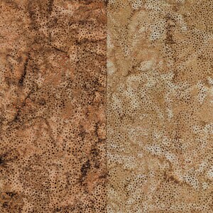 May include: Two-panel fabric with a mottled pattern. The left panel is primarily brown with darker brown spots and veins. The right panel is tan with brown spots. The fabric has a textured appearance.