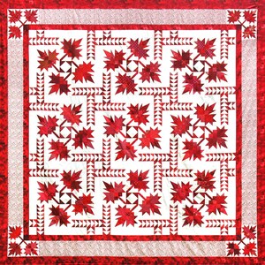 May include: A square quilt with a white background and a repeating pattern of red maple leaves. The leaves are surrounded by white triangles. The quilt has a red border with a dotted pattern.