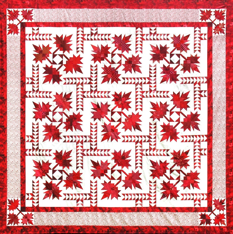 May include: A square quilt with a white background and a repeating pattern of red maple leaves. The leaves are surrounded by white triangles. The quilt has a red border with a dotted pattern.