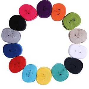 May include: A collection of colorful, coiled ribbons arranged in a circular pattern. The ribbons are in various shades, including pink, purple, orange, green, gray, blue, red, yellow, and teal. The background is plain white.