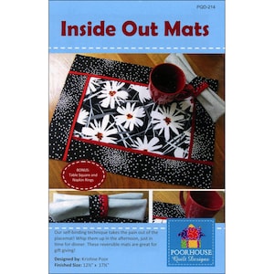 May include: A placemat with a black and white floral design, red trim, and a dotted border. The text "Inside Out Mats" is at the top. Includes a bonus table square and napkin rings. Finished size is 12.5" x 17.5".
