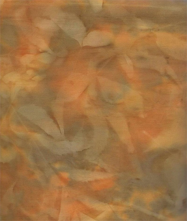 May include: Textile artwork with an abstract design. The fabric displays a mix of warm colours, including orange, tan, and light brown. The textured surface creates a layered effect. The design has a soft, organic feel with subtle variations in tone and shading.