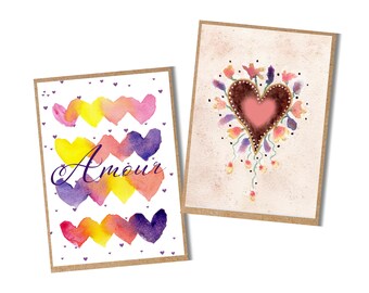 May include: Two greeting cards with watercolour heart designs. One card features colourful hearts and the word "Amour". The other card has a heart surrounded by flowers. Both cards have a brown border and are on a white background.
