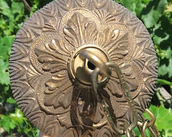 Op de afbeelding: Oud-stijl plafondrozet in brons. De cirkelvormige rozet heeft gedetailleerde bloemen- en bladerpatronen. Een messing ketting en ring zijn bevestigd om op te hangen. De armatuur is ontworpen voor een vintage of klassieke esthetiek.