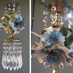 May include: A gold chandelier with blue and white porcelain flowers and crystal drops.