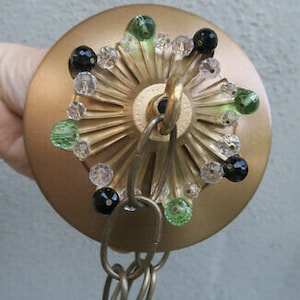 May include: Gold ceiling fixture with a chain and a decorative ring of green and black glass beads.