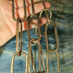 Op de afbeelding: Een gouden ketting gemaakt van ovale schakels. De ketting is gemaakt van metaal en heeft een glanzende afwerking.