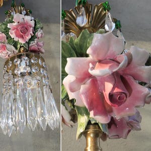 May include: A vintage chandelier with a pink porcelain rose and crystal drops. The chandelier is made of brass and has a floral design.