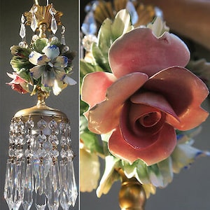 May include: A chandelier with a floral design featuring pink and white roses, blue and white flowers, and green leaves. The chandelier is adorned with crystal prisms.