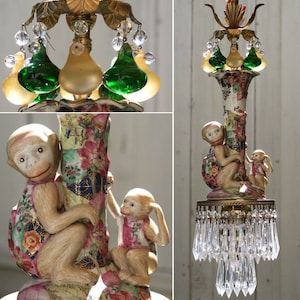 May include: A porcelain chandelier with a floral design and two monkeys. The chandelier has a crystal drop pendant and green glass accents.
