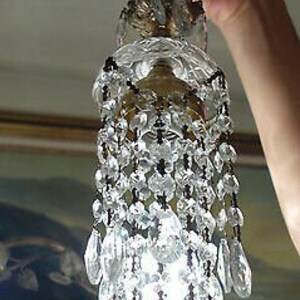May include: A crystal chandelier with a brass fixture and a cascading design of crystal drops.