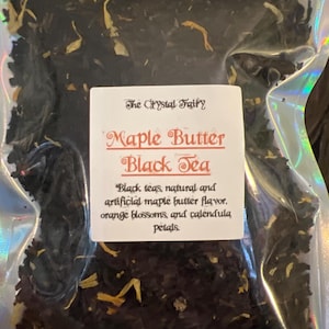 Puede incluir: Una bolsa transparente y sellada llena de té negro de hojas sueltas. Una etiqueta blanca dice "Maple Butter Black Tea" con detalles sobre los ingredientes del té, incluido el sabor a mantequilla de arce.