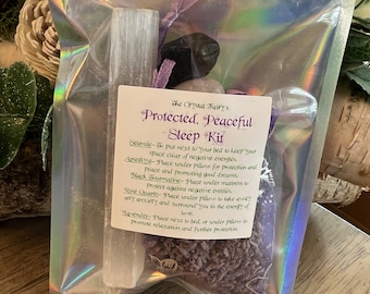 Puede incluir: Una bolsa transparente que contiene un kit para dormir. El kit incluye un cristal de selenita blanco, turmalina negra, cuarzo rosa, lavanda y una etiqueta que dice "Protected, Peaceful Sleep Kit."