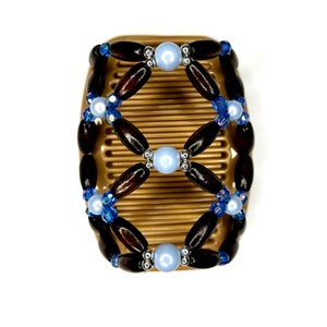 May include: A brown hair comb with a wooden beaded design. The beads are brown, blue, and white.