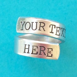 May include: A silver ring with the words "YOUR TEXT HERE" engraved on it.
