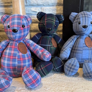 May include: Three plaid teddy bears in blue, green, and blue-red patterns. Each bear has a brown patch with text. The bears have black button eyes and are sitting. The bears are a soft, plush toy.