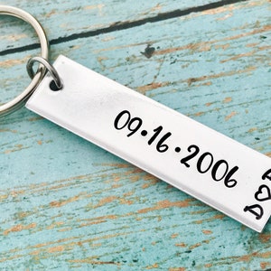 May include: Silver keychain with a rectangular tag engraved with the date 09.16.2006 and the letters "D & R" with a heart symbol.