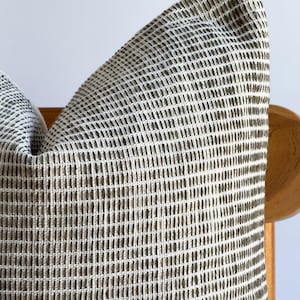 May include: A brown and white patterned throw pillow with a woven texture.