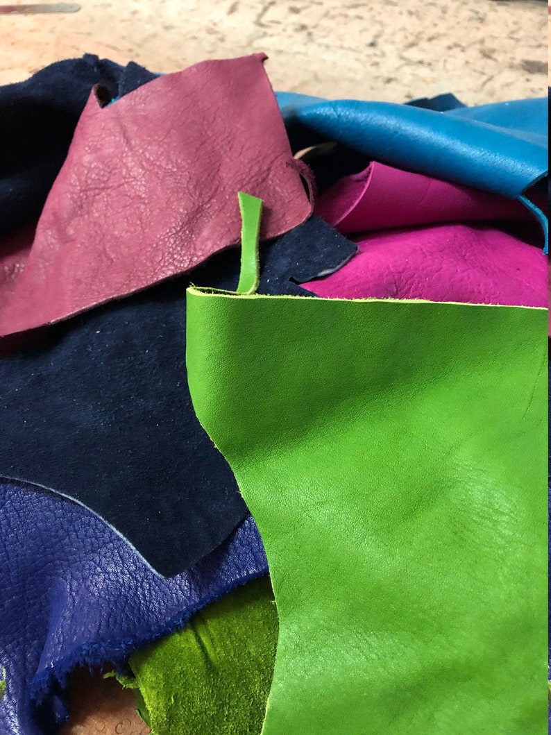 Pu&ograve; includere: Assortimento di ritagli di pelle in vari colori, tra cui verde, blu, rosa e viola. La pelle &egrave; testurizzata e sembra essere pelle vera.