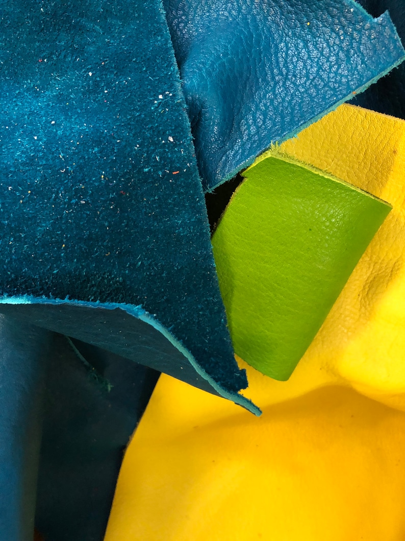 Pu&ograve; includere: Primo piano di tre pezzi di pelle di diversi colori: verde acqua, giallo e verde. La pelle &egrave; testurizzata e ha un aspetto naturale.