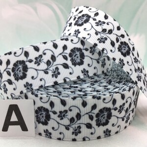May include: White satin ribbon with a black floral print. The ribbon is rolled up and the label "A" is visible.