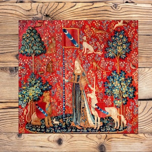 May include: A tapestry featuring a woman in a flowing gown holding a unicorn's horn. The tapestry is set against a red background with a variety of trees, flowers, and animals, including a lion, a dog, and a bird. The woman is wearing a crown and a blue and white sash.