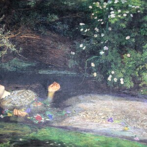 May include: A painting depicting a woman lying in a stream of water. She is wearing a white dress and has flowers in her hair. The water is clear and the sky is blue.