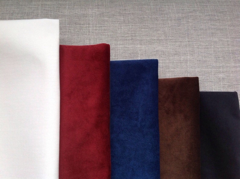 May include: Five fabric swatches, one white and four different shades of velvet: burgundy, navy blue, brown, and black.