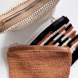 Può includere: Tre pochette con cerniera all'uncinetto in crema, marrone e nero con inserti in pelle marrone chiaro. La pochette color crema è lunga e rettangolare, mentre le pochette marroni e nere sono più piccole e rettangolari. Tutte hanno cerniere dorate.