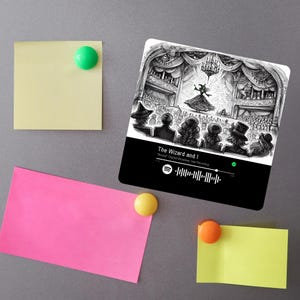 May include: A black and white illustration of a stage scene with a witch in a green dress and a crowd of people watching. The text "The Wizard and I" is displayed below the image, along with a Spotify logo and a barcode.