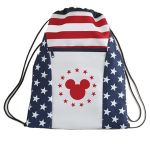 May include: A white drawstring bag with a red and blue American flag design. The bag has a zippered pocket and a red Mickey Mouse silhouette in the center.