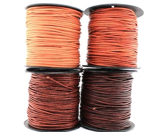 May include: Four spools of leather cord in two colors: brown and orange. The spools are stacked on top of each other.