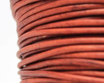 May include: A spool of brown leather cord, wound tightly in a coil.
