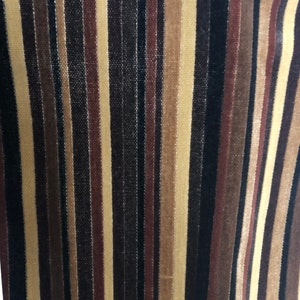 Peut inclure: Tissu rayé avec des bandes alternées de brun, beige et noir. Le tissu a un léger brillant et une surface légèrement texturée.