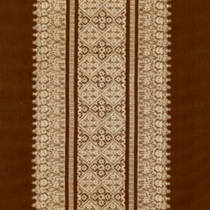 Puede incluir: Primer plano de una tela marrón con un intrincado diseño bordado en crema. El diseño presenta una banda vertical central con patrones geométricos, flanqueada por bordes decorativos. La textura de la tela es visible, sugiriendo un material suave.